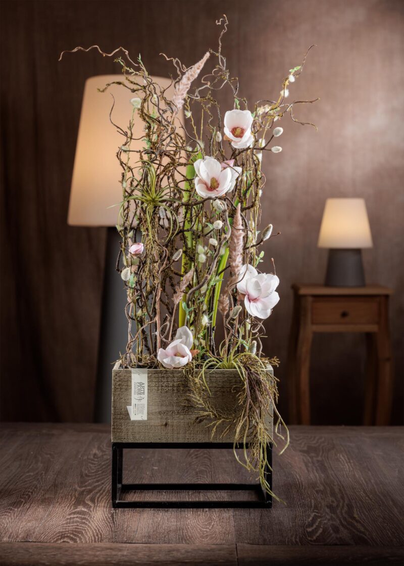 Composizione di fiori artificiali finti con magnolia in vaso di legno