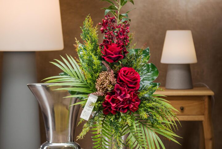 Mazzo fiori artificiali per loculo con rose e foglie di palma in vaso.