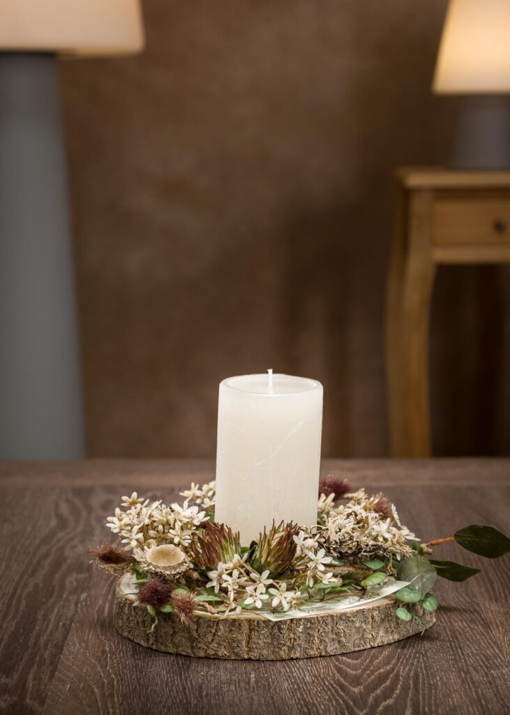 Composizione centrotavola con candele e fiori finti vista frontale